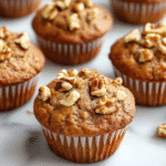Gluten Free Banana Nut Bread Muffins: A Complete Guide 7 Close-up of gluten free banana nut bread muffins with chopped walnuts on top, displayed on a marble surface.